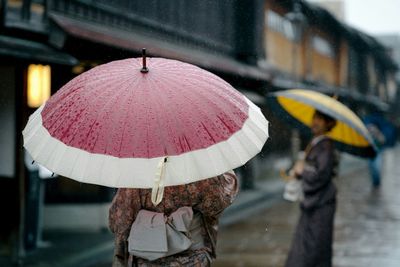 Pink umbrella on rainy day in city