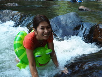 Portrait of smiling young woman in river