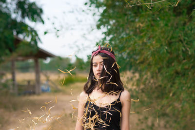 Portrait of young woman standing on field