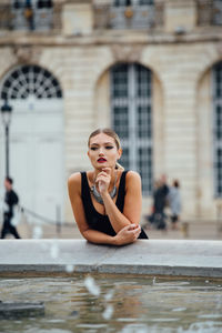 Young woman sitting in front of house