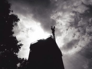 Low angle view of silhouette statue against sky