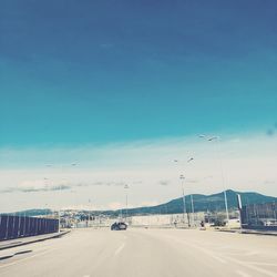 Cars on road against blue sky