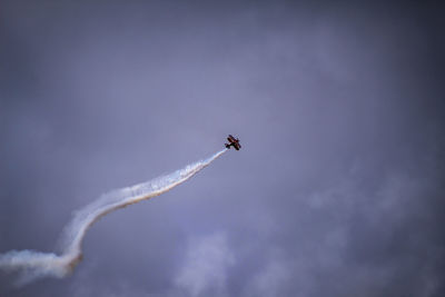 Low angle view of airplane flying against sky