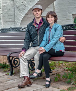 Portrait of young couple sitting on bench