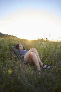 Woman lying on a meadow at sunset.