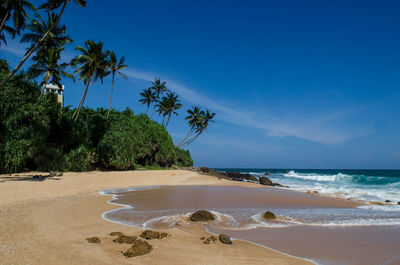 Scenic view of beach against blue sky