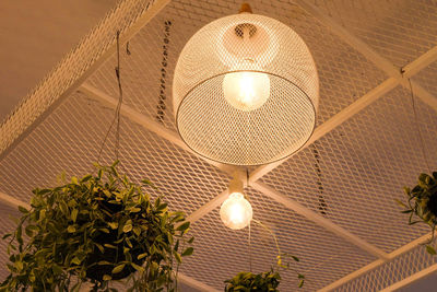 Low angle view of illuminated pendant lights hanging from ceiling
