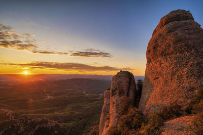 Scenic view of rock formation against sky during sunset