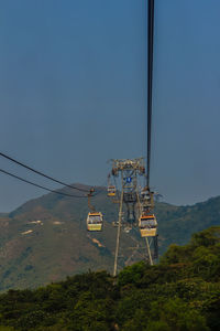 Low angle view of overhead cable car against sky