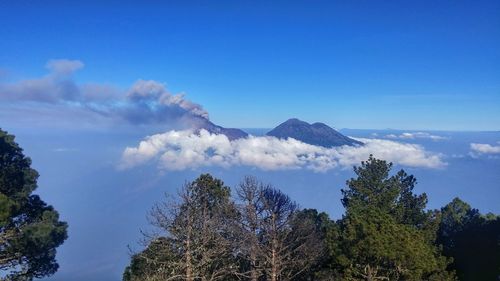 Scenic view of mountains and cloudscape against blue sky