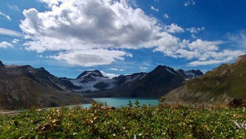 Scenic view of mountains and lake against cloudy sky