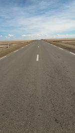 Road passing through land against sky