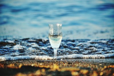 Surface level of wineglass on shore at beach