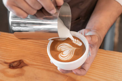 Midsection of man holding coffee cup