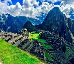 High angle view of green field against cloudy sky