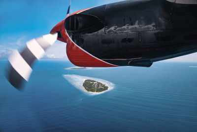 Maldives, kolhumadulu atoll, personal perspective of paraglider flying over small islet in indian ocean