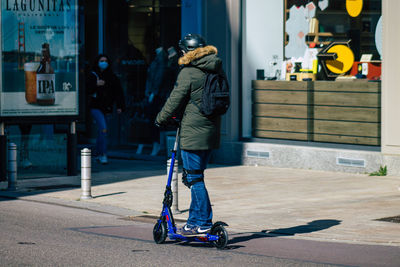 Rear view of man skateboarding on street