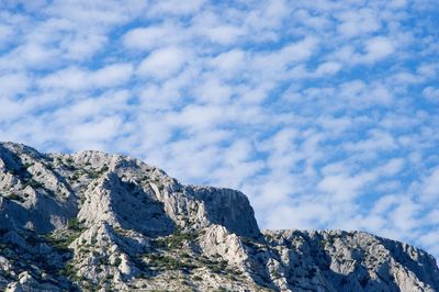 Low angle view of snowcapped mountain against sky