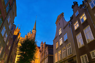 Low angle view of buildings against clear blue sky