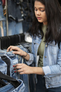 Young woman looking down while standing outdoors