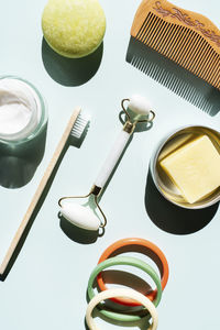 Studio shot of wooden comb, bamboo toothbrush, colorful bracelets, organic soap, shampoo and other eco-friendly self-care products