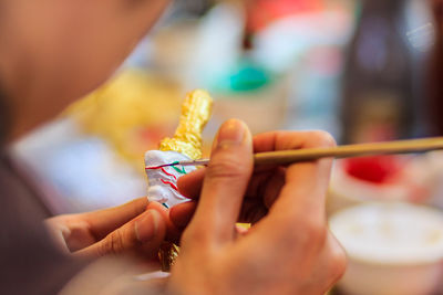 Cropped image of sculptor painting souvenir