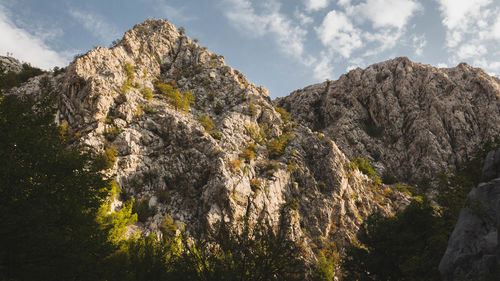 Low angle view of rocky mountains against sky