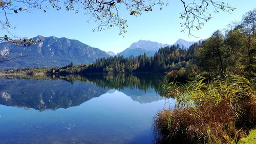 Scenic view of lake and mountains against clear blue sky