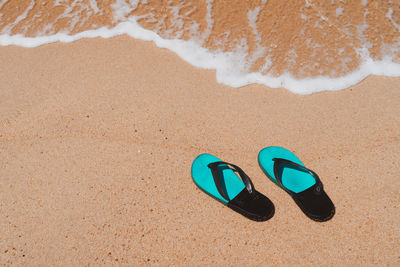 High angle view of shoes on sand at beach