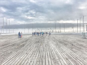 People on snowy field against sky