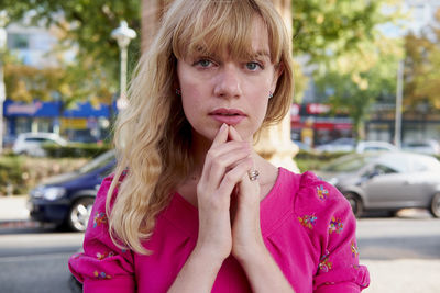 Portrait of beautiful woman standing against cars