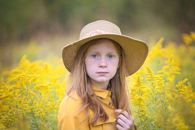 Young girl in yellow dress in a field of flowers