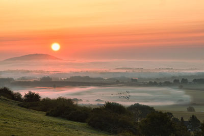 Scenic view of field against sky during sunset