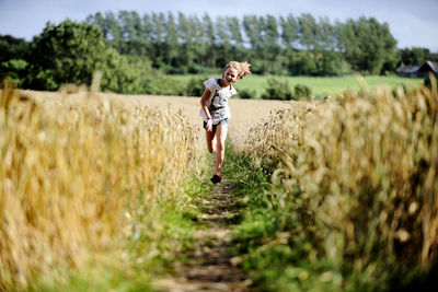 Girl running through wheat field