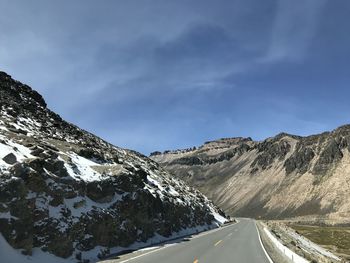 Road amidst snowcapped mountains against sky