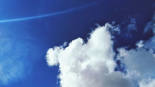 Low angle view of vapor trail in blue sky