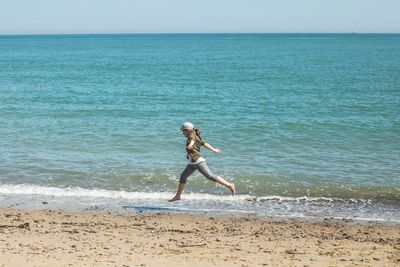 Full length of man standing on beach against clear sky