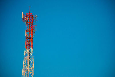 Low angle view of communications tower against clear blue sky