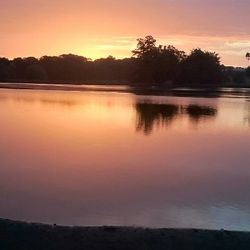 Scenic view of lake against sky at sunset