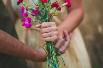 Midsection of woman holding flower