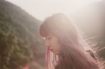 Close-up of beautiful woman looking down on sunny day