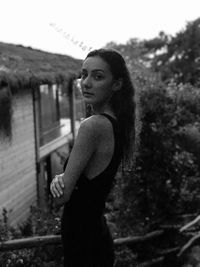 Side view of young woman standing against clear sky