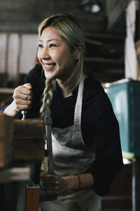 Happy young female entrepreneur working at upcycling workshop