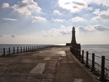 Lighthouse against cloudy sky