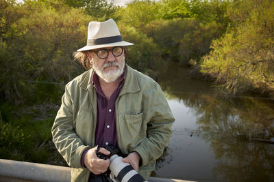 Portrait of young man wearing hat standing in lake