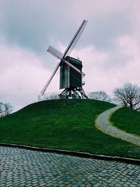 Traditional windmill on field against sky