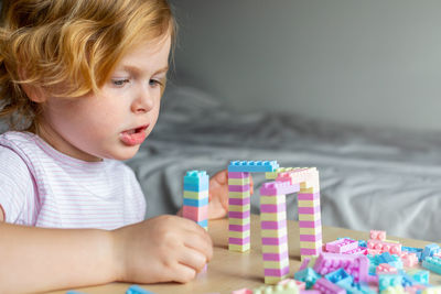 Cute girl playing with building blocks