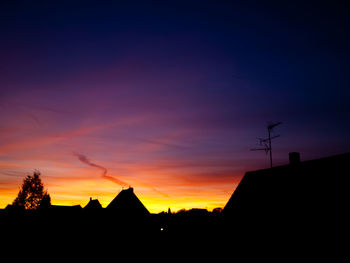 Low angle view of silhouette buildings against sky at sunset