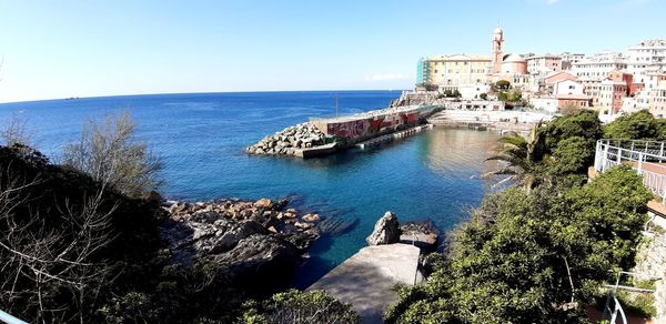 High angle view of buildings by sea against sky