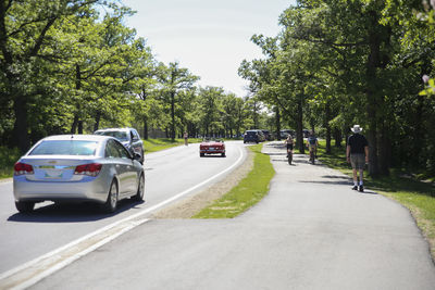 Rear view of man riding motorcycle on road in city